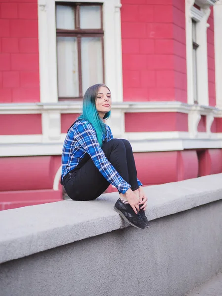 Chica Hipster con el pelo teñido de azul. Mujer con piercing en la nariz, orejas túneles y peinado inusual divirtiéndose, posando en la ciudad europea. Concepto despreocupado . — Foto de Stock