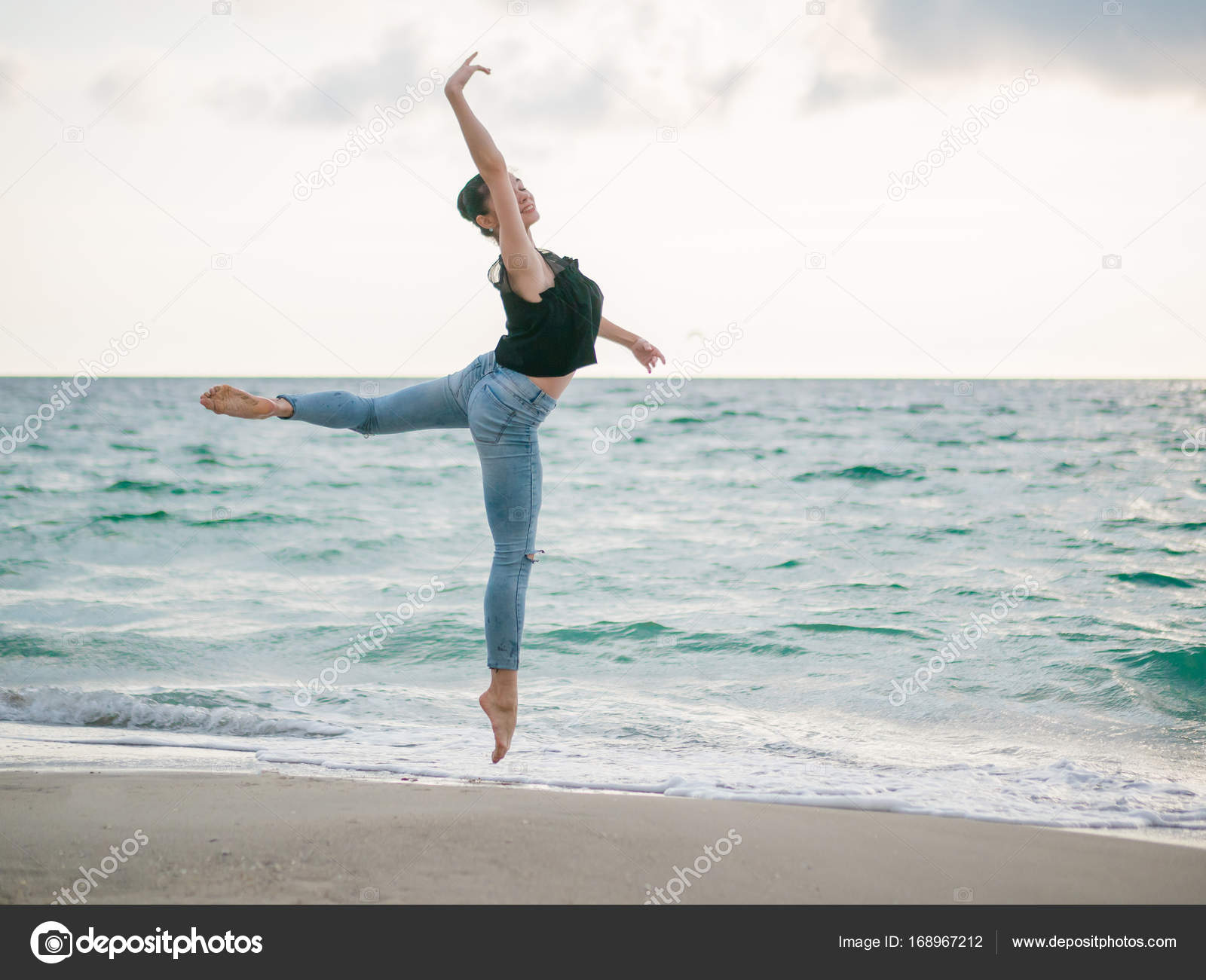 Blinke gentage lidenskabelig Beautiful scene of a dancing ballerina in black top and jeans on sandy  beach ocean or sea in morning. Beautiful brunette woman practicing  stretching and exercises.Copy space Stock Photo by ©kohanova1991 168967212