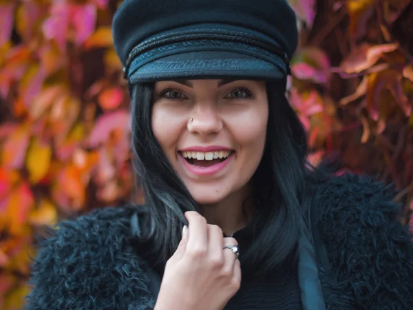 Sezon jesień. Uśmiechający się atrakcyjna kobieta relaks na świeżym powietrzu w jesienny park, ciesząc się słoneczny dzień. Modny dziewczyna w ciepłe modne ubrania i cap poza. — Zdjęcie stockowe