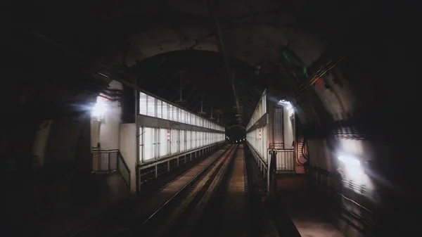 Blick auf den U-Bahn-Tunnel aus dem hinteren Fenster eines fahrenden Zuges. Schnelle U-Bahn fährt von moderner U-Bahn-Station ab. — Stockfoto