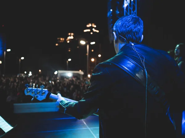 Grupo de pop rock tocando concierto en vivo en el escenario por la noche. Vocalista de espalda cantar y tocar la guitarra eléctrica en la escena — Foto de Stock