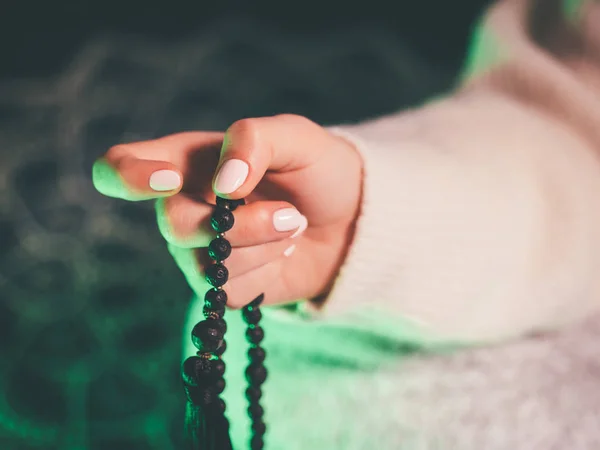 Donna, mano illuminata da vicino, conta Malas, fili di perline di pietre preziose utilizzate per tenere il conto durante le meditazioni mantra . — Foto Stock