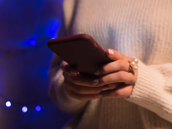 Bokeh tatil Noel ışıkları, arama ya da sosyal ağlar kavramı, sms mesajı arkadaşlarına yazarak hipster ile gece smartphone kullanarak eller yakın çekim görüntüsü — Stok fotoğraf