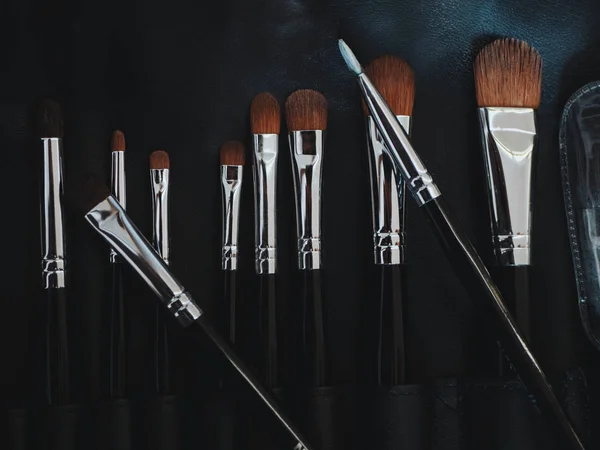 Set of flat top view of various professional female cosmetics brushes for makeup and eyelash brush on black background, — Stock Photo, Image