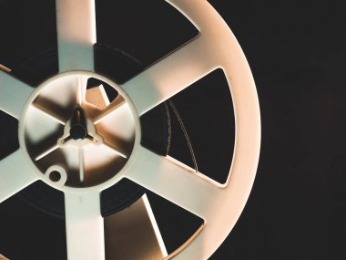 Gece karanlık odada oynayan eski 8 mm film projektör. Dönüş makara bant video, ses kayıt cihazı veya oyuncu ile. Bir makara ile bir film Close-Up.