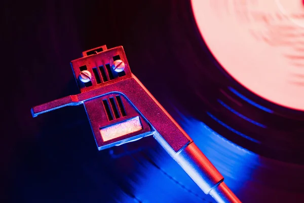 Film van retro-gestileerde record player vinyl zwart record spinnen. Cinemagraph. Bovenaanzicht. Prachtige neonkleuren van de nacht. — Stockfoto