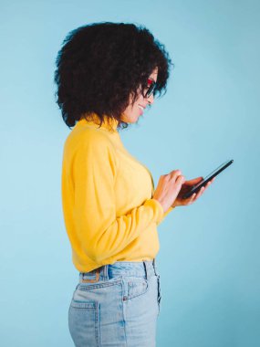 Eğitim, okul, insanlar ve öğrenme kavramı - Afrika öğrenci kız tablet pc bilgisayar ile mavi arka plan üzerinde gülümseyen. e-kitap okumak için kullanan kadın.