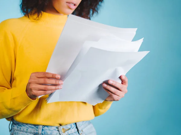 Onderwijs en bedrijfsleven concept - internationale student op de universiteit studeert. Of moderne Afrikaanse Amerikaanse zakenvrouw met afro kapsel lezen van documenten op blauwe achtergrond in de studio. — Stockfoto