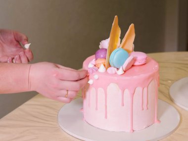 Unrecognisable kadın dekorasyon mousse sır kek ile gül, macarons, ayrıntı, odak kek üzerine eller. DIY, sıralı, adım adım, bir parçası serisi.
