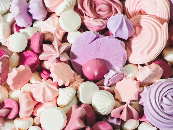 Closeup of home baked pink and violet meringues cookies with sugar. Homemade meringue kisses.