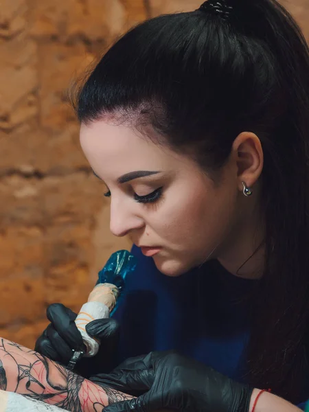 Menekşe giyim dövme yapma esmer kadın tattooer portresi müvekkili silah Studio ile kolu mans. Genç iş kadını atölye. — Stok fotoğraf