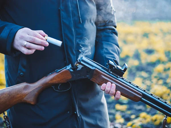 Sports shooting. Hunter reloading cartridge in field. Smoke from the trunks of smooth-bore hunting rifle after firing. — Stock Photo, Image