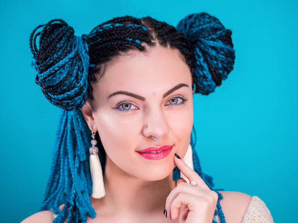 Glamour luxury portrait of sexy woman with african blue braids hairstyle, bindi, nose ring and tassel earrings isolated on colorful background. Girl in fur, bright makeup, hipster, freaky