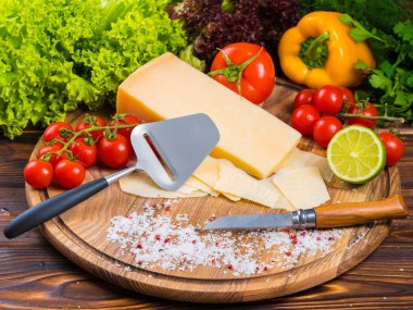 Üstten Görünüm. parmesan peyniri, taze kiraz domates, marul, deniz tuzu, limon, kırmızı biber ve Bulgar kırmızıbiber ile ahşap tahta. Bıçak kesim sebze. İştah açıcı natürmort
