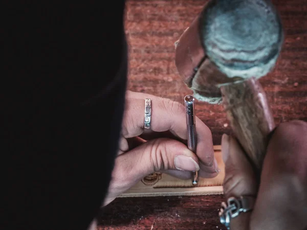 Close up of leather craftsman working with natural leather using hammer. Handbag master at work in local workshop. Handmade concept. Male shoemaker creating product with textile — Stock Photo, Image
