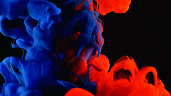 红色和蓝色墨水在水射击用高速照相机。血腥的油漆掉落, 反应, 形成抽象的云形成和变形的黑色。艺术背景. — 图库照片