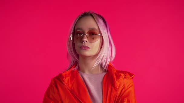 Millennial enigmática menina bonita com penteado tingido rosa incomum. Lantejoulas douradas como lágrimas, piercing no nariz. Misterioso hipster adolescente em óculos . — Vídeo de Stock