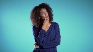 Gülümseyen Afrikalı kız Eureka hareketi yapıyor. Düşünen genç iş kadınının portresi mavi arka planı işaret eden bir fikir.