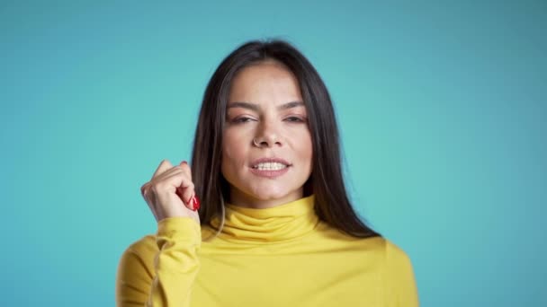 Hispanic vacker kvinna håller ett finger på sina läppar över blå bakgrund. Gest av shhh, hemlighet, tystnad. Närbild. — Stockvideo