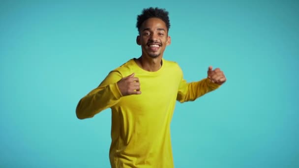 African american man dancing on blue studio background. Unstoppable fun, happiness, comical portrait of young guy isolated. — Stock Video