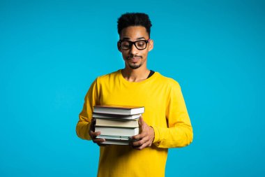 Afrikalı öğrenci ev ödevi ve kitap miktarından memnun değil. Gözlüklü adam, çalışmalardan bıkmış, hayal kırıklığına uğramış..