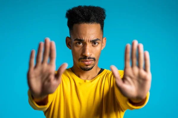 No, nunca, apuesto hombre afroamericano detestando y rechazando el gesto por señal de stop. Retrato de un joven exitoso y confiado hombre aislado en azul — Foto de Stock