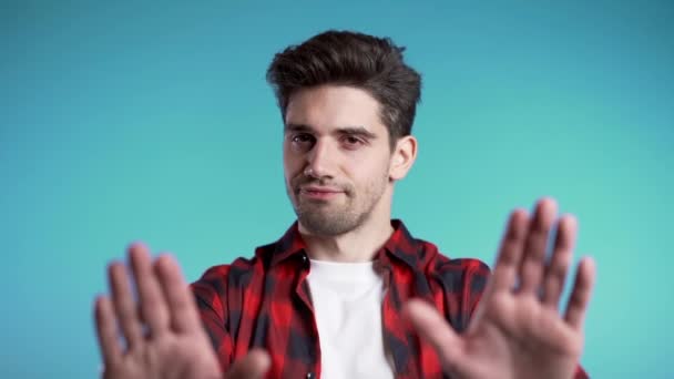 No, never, handsome brunette man disliking and rejecting gesture by stop sign. Slow motion. Portrait of young successful confident guy isolated on blue — Stock Video