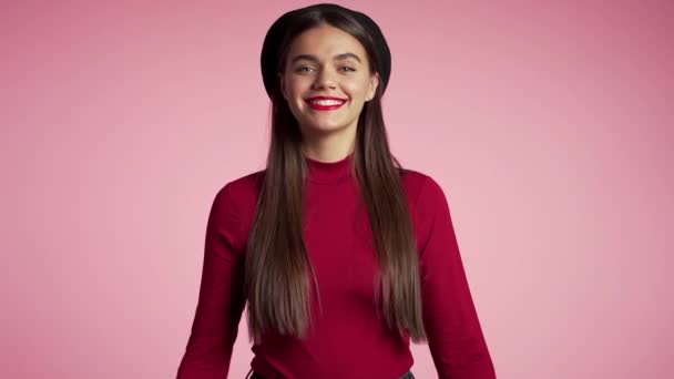 完璧な赤い唇のメイクとピンクの背景の上にOKサインを作るフランスの帽子を持つ若いヒップスター女性。勝者だ成功だ肯定的な女の子のカメラに笑顔。ボディランゲージスローモーション. — ストック動画