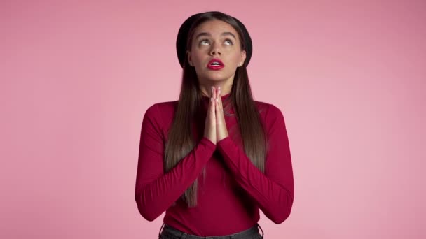 Atraktivní žena s dlouhými vlasy modlí nad červeným pozadím. Hezká holka, která někoho prosí. Koncept naděje. — Stock video