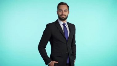Mavi stüdyo arka planında sakallı başarılı iş adamının portresi. Takım elbiseli bir adam kameraya bakıp gülümsüyor. Yakışıklı bir adamın portresi..