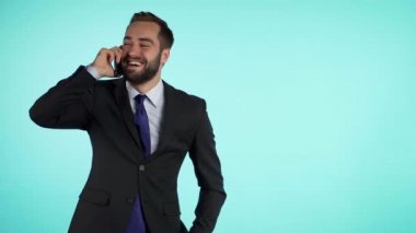 İşadamı mavi arka planda izole edilmiş cep telefonu kullanarak konuşuyor. Uzayı kopyala Resmi takım elbiseli bir iş adamı iş arkadaşıyla memnuniyetle konuşur. Ofis çalışanı, maaşlı işçi, hafta içi konsepti.