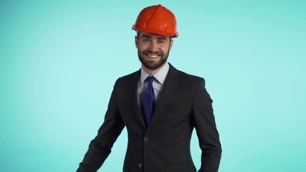 Portrait of young successful engineer in corporate business suit and construction helmet on head. Businessman showing thumbs up sign gesture. Protective clothing. — Stock Video