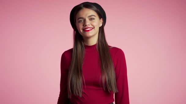 Ganador. Éxito. Chica positiva sonríe a la cámara. El lenguaje corporal. Joven mujer hipster con maquillaje perfecto labios rojos y sombrero francés haciendo signo OK sobre fondo rosa. Movimiento lento . — Vídeos de Stock