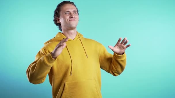 Jeune homme souriant et dansant danse drôle de bonne humeur sur fond bleu. Amusement imparable, bonheur, portrait comique d'un gars isolé . — Video