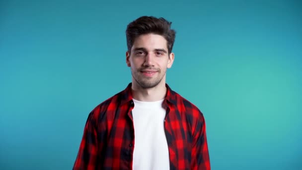 Positive young man smiles to camera. Hipster guy showing OK sign over blue background. Winner. Success. Body language. 4k — Stock Video