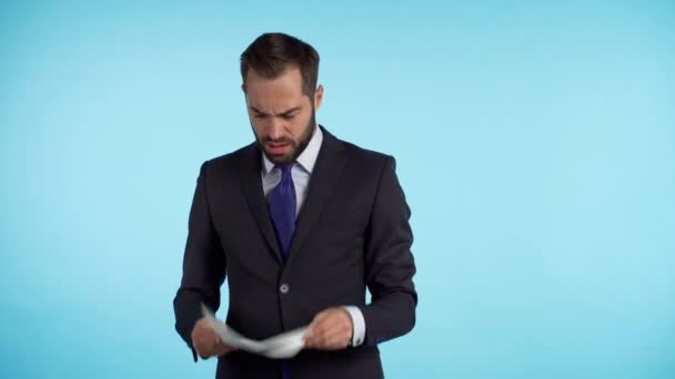 Giovane bell'uomo in giacca e cravatta controlla documenti, bollette, rapporto. L'uomo d'affari stropiccia il foglio di carta e lo getta sul pavimento. 4k — Video Stock