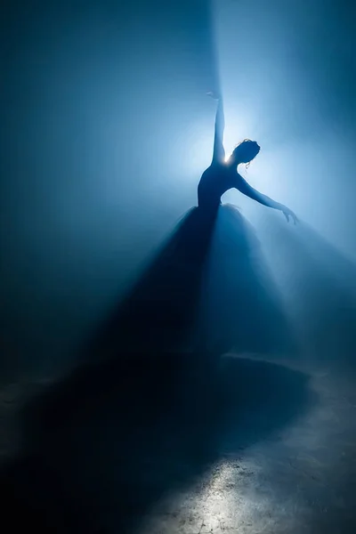 Desempenho solo por bailarina em tutu contra pano de fundo de holofotes luminosos — Fotografia de Stock