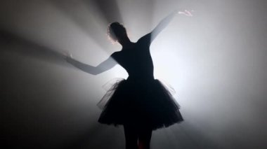 Sahne ışıkları altında dans eden profesyonel balerin büyük sahnede sigara içiyor..