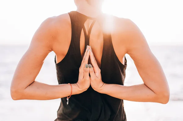 Mulher irreconhecível faz saudação ao sol ao nascer do sol. Mãos nas costas namaste. Yoga, meditação, gratidão, conceito de estilo de vida saudável . — Fotografia de Stock