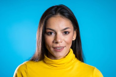 Sarı elbiseli, mavi duvar arkasından gülümseyen güzel, neşeli, melez bir ırk kadını. Tatlı İspanyol kızların portresi..