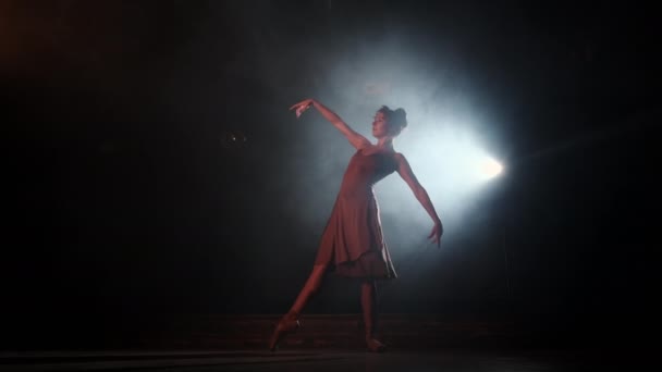 Graciös ballerina i beige klänning dansande element av klassisk balett bakgrundsbelysning — Stockvideo