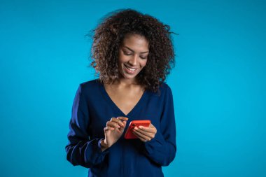 Akıllı telefonlu bir iş kadını. Öğrenci kız cep telefonu kullanıyor. Mobil cihazda internette sörf yapan güzel bir kadın. Modern teknoloji aygıtına sahip bir kadın..