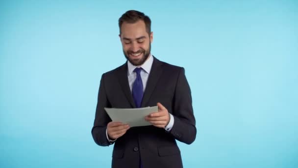 Joven hombre guapo en traje cheques documentos, facturas de servicios públicos, informe . — Vídeo de stock