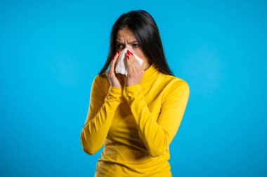 Genç İspanyol kız mendile hapşırıyor. Tecrit edilmiş kadın hasta, soğuk almış ya da alerjik reaksiyonu var. Sağlık, ilaç, hastalık, tedavi kavramı