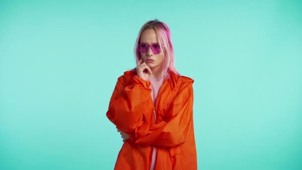 Porträt eines denkenden jungen Hipster-Mädchens auf blauem Hintergrund. — Stockvideo