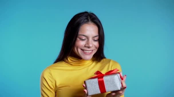 Mooie vrouw ontving een geschenkdoos en geïnteresseerd in wat erin zit. Ze is gelukkig. — Stockvideo