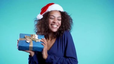 Güzel Afrikalı Amerikalı kadın, üzerinde yay olan bir hediye kutusu aldı. O mutlu. 