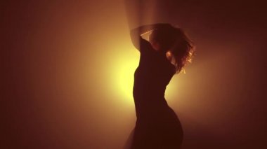 Harika bir kadın neon ışıkta dans ediyor. Profesyonel dansçı, müzik ritmine göre hareket ediyor. Yavaş çekim.