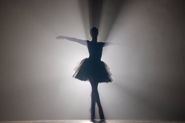 Sahne ışıkları altında dans eden profesyonel balerin büyük sahnede sigara içiyor..