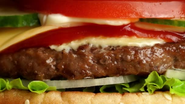 Burger de bœuf juteux avec escalope, oignon, légumes, fromage fondu, laitue, sauce — Video